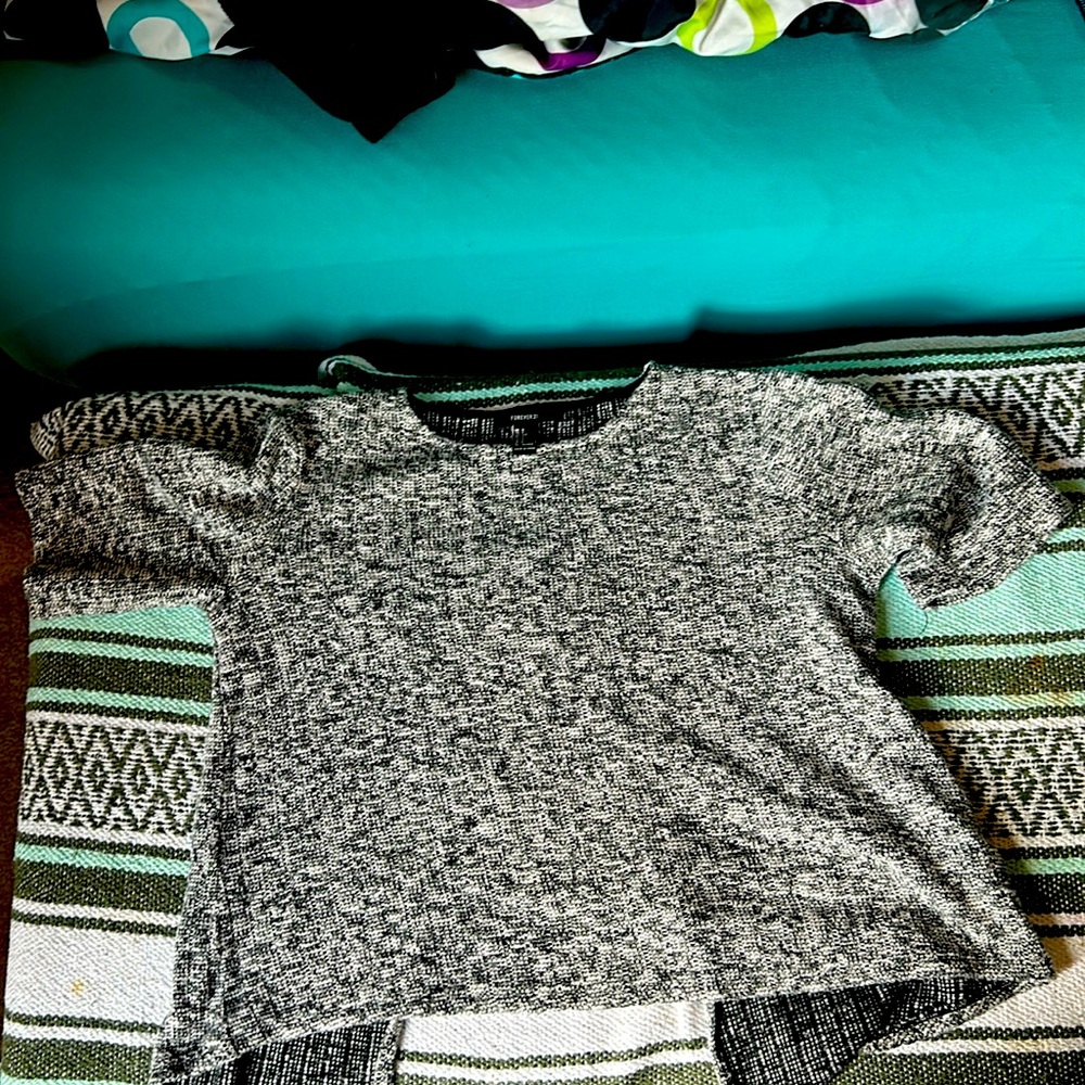 A black and white short sleeve sweater with a slit in the back.